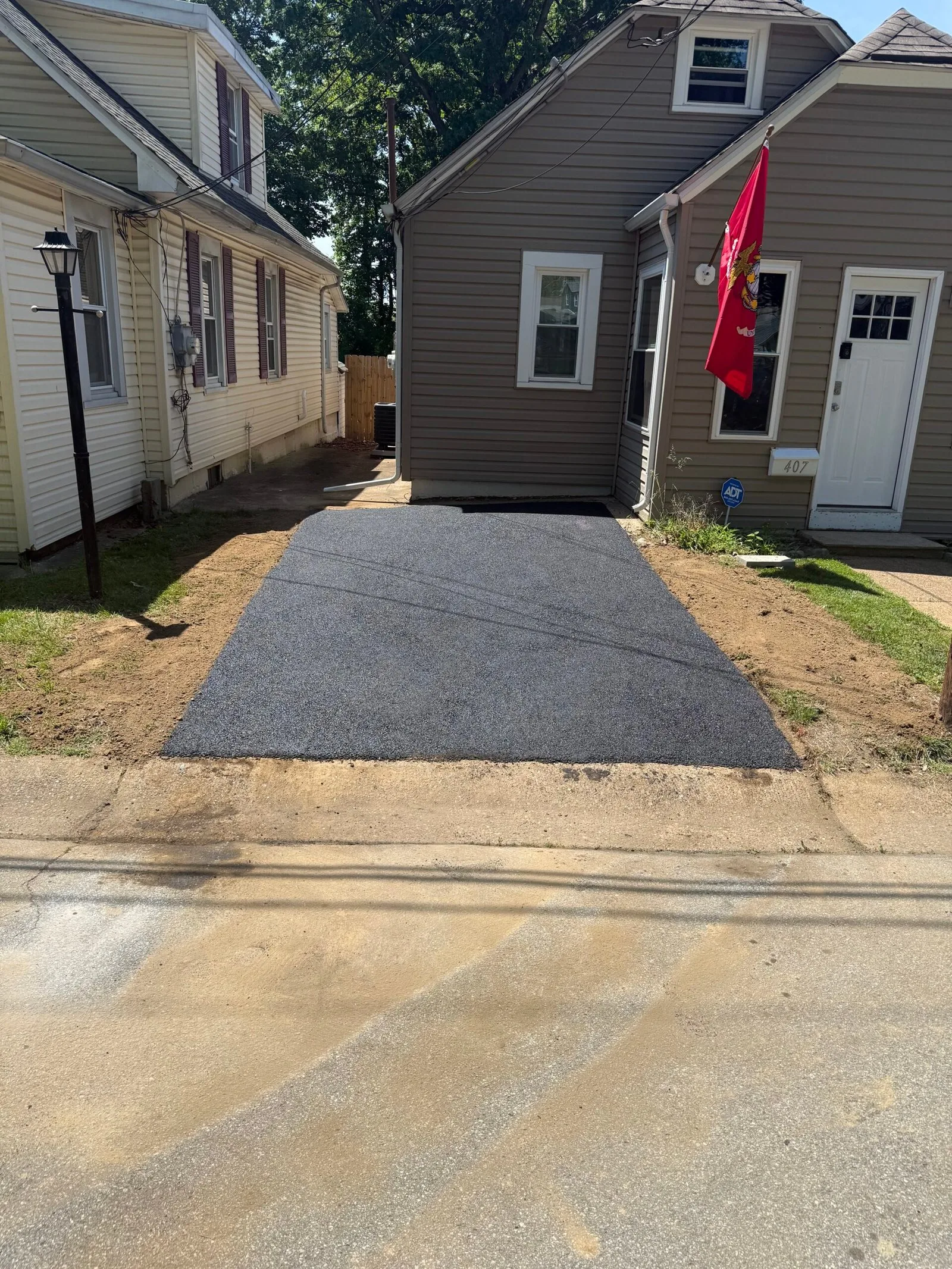 Professional sealcoating application on residential driveway